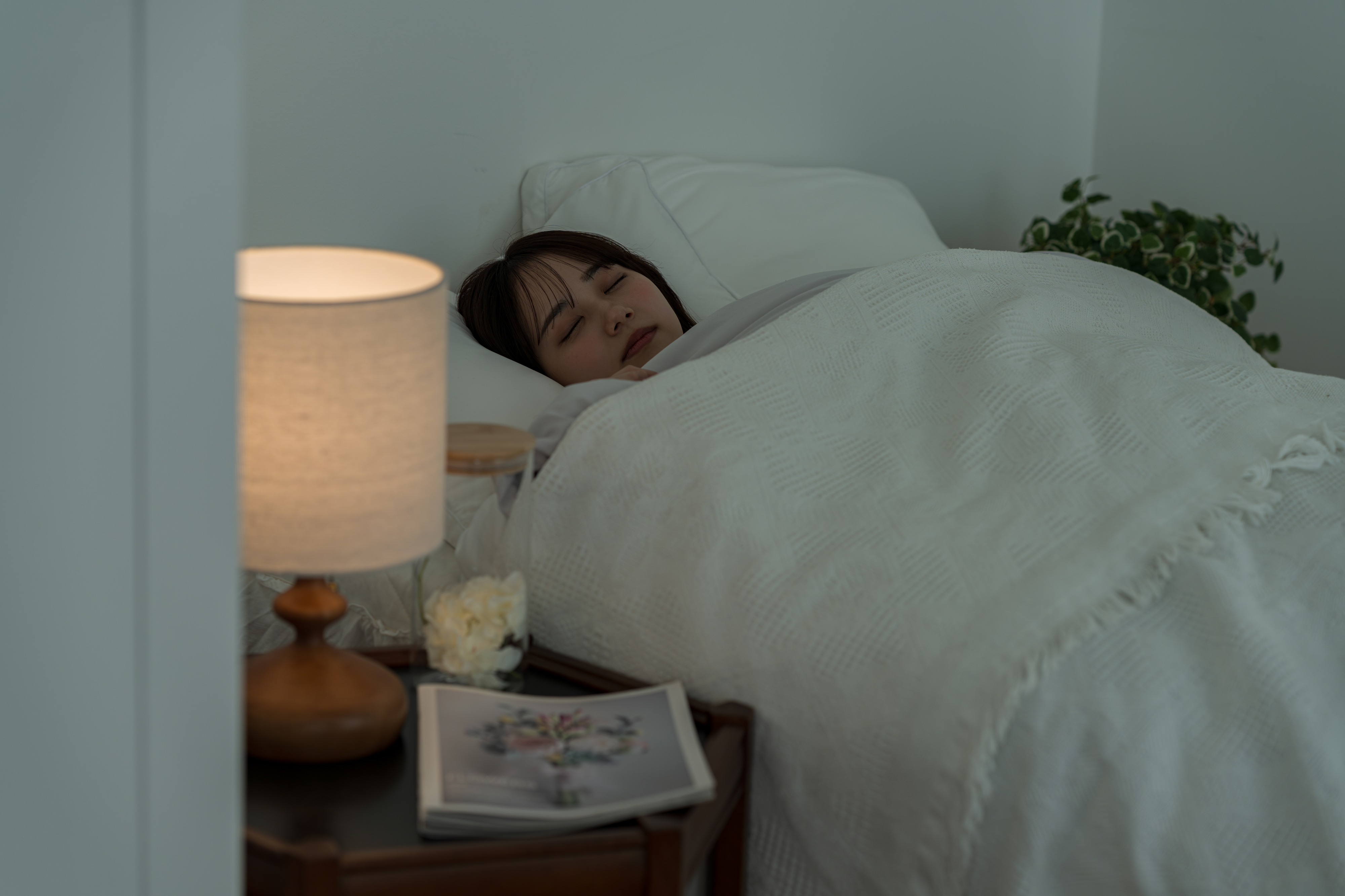 夜の寝室で眠る人とランプ