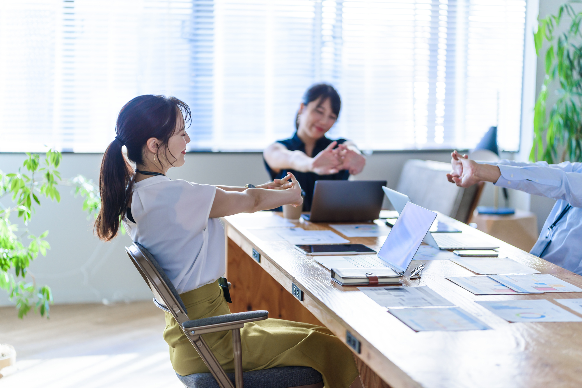 オフィスで伸びをする人たち